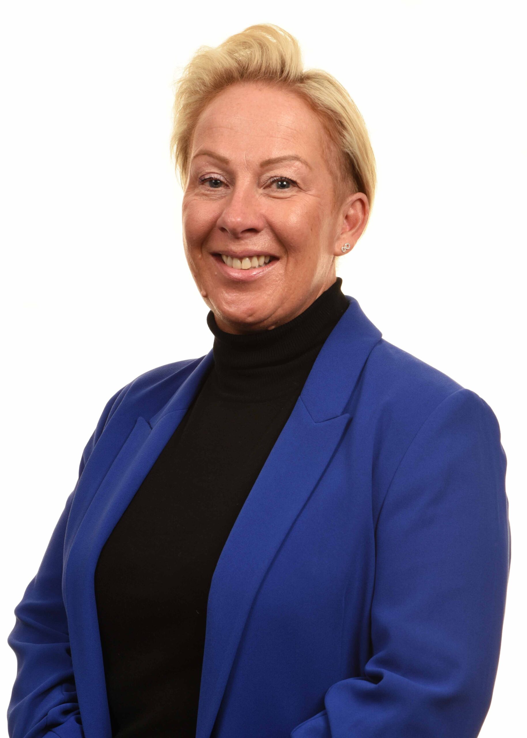 Headshot of Rachel Barlow - she is smiling at the camera, wearing a black polo neck and royal blue blazer