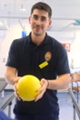 Male physiotherapist holding a yellow ball